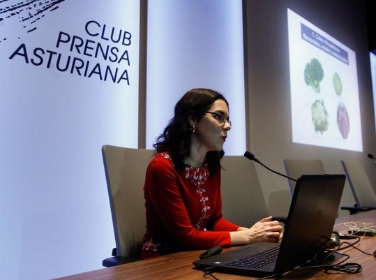 Paula Jiménez Fonseca sentada en la mesa impartiendo la charla en la sede de La Nueva España de Oviedo